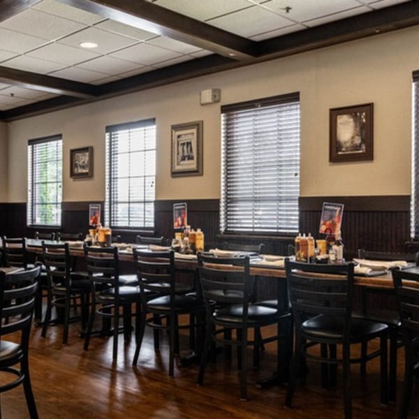 Interior of Half Moon Restaurant & Brewery with dining tables, chairs, and windows with blinds.