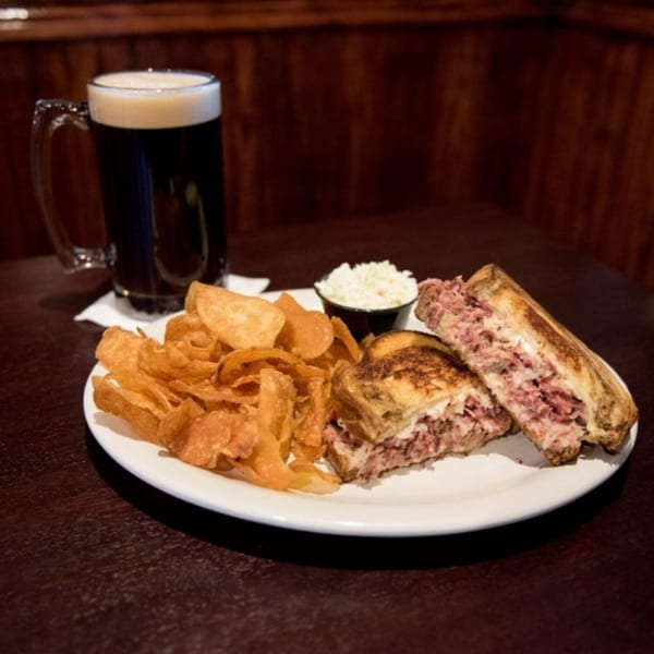 Half Moon Restaurant & Brewery's reuben sandwich with chips, coleslaw, and a dark beer.